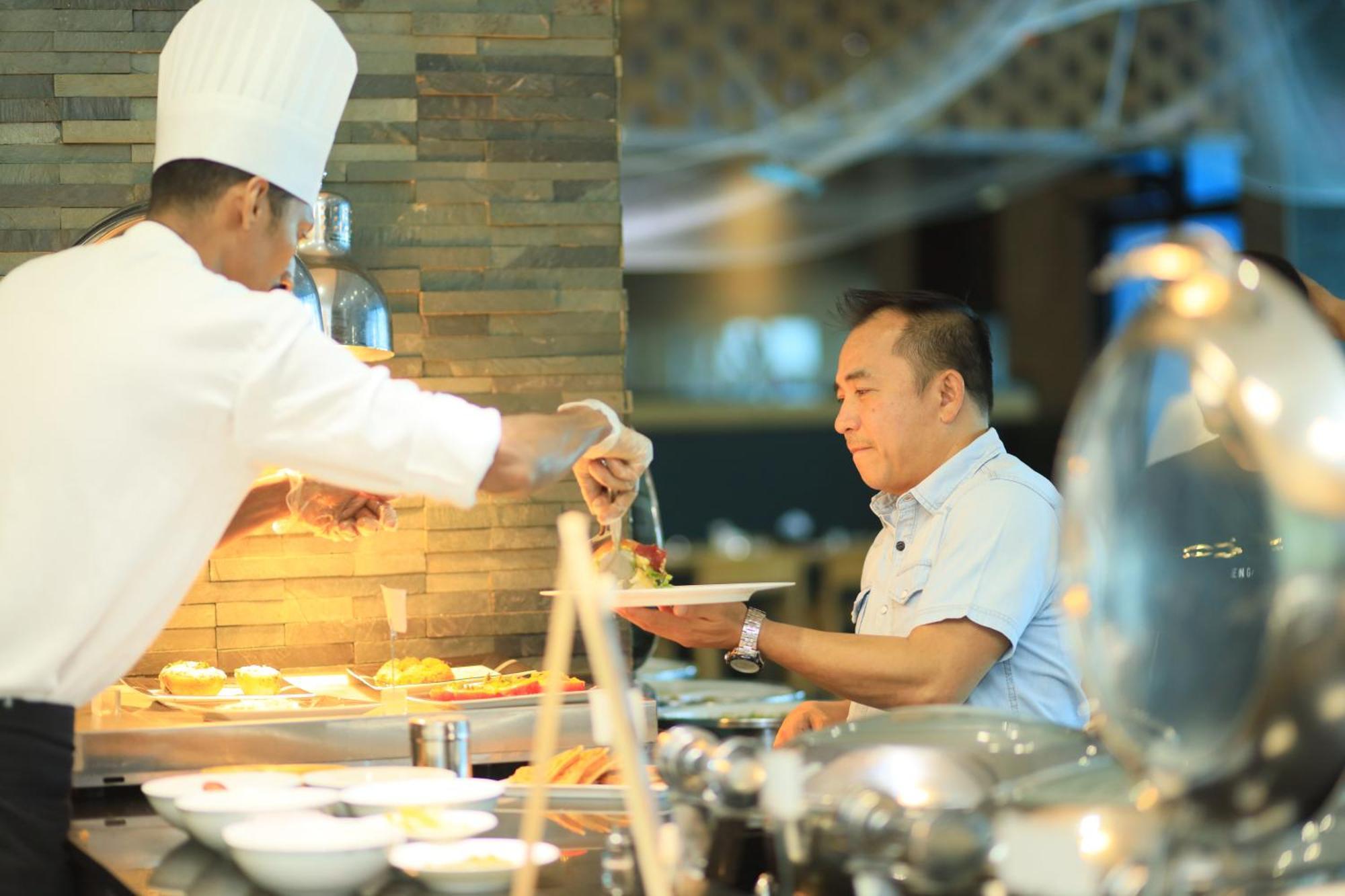 ラミー グランド ホテル アンド スパ マナーマ エクステリア 写真 A chef serving food at a buffet